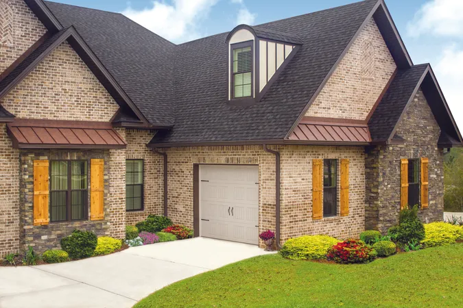 Almond short panel residential garage door installed on a brick home