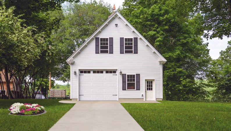 White garage door with vertical long panels and stockbridge windows on a white two-story house