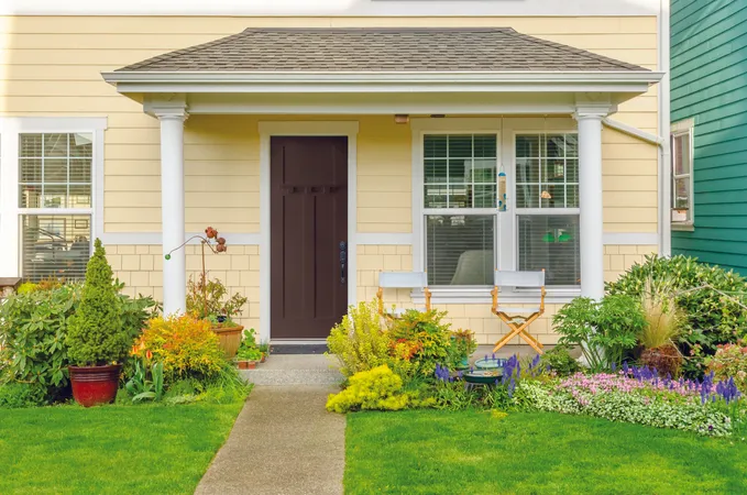 Brown shaker style, smooth entry door on a contemporary home with light yellow siding