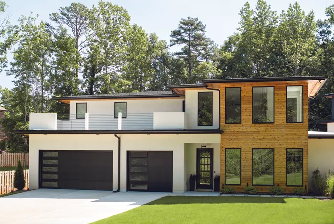 Black flush panel garage door with clear windows on a modern home