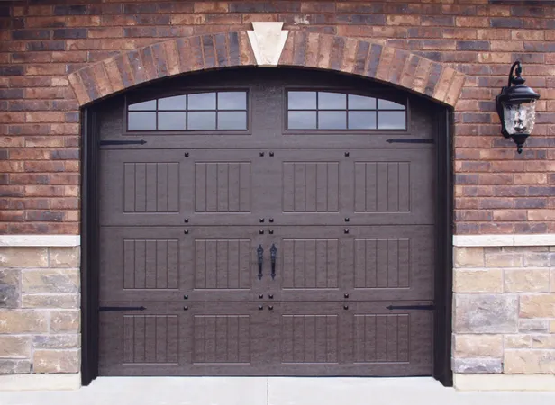 Brown vertical short panel garage door with arched stockton windows and decorative hardware