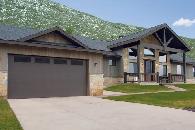 Black residential garage door with windows, installed in a suburban family home